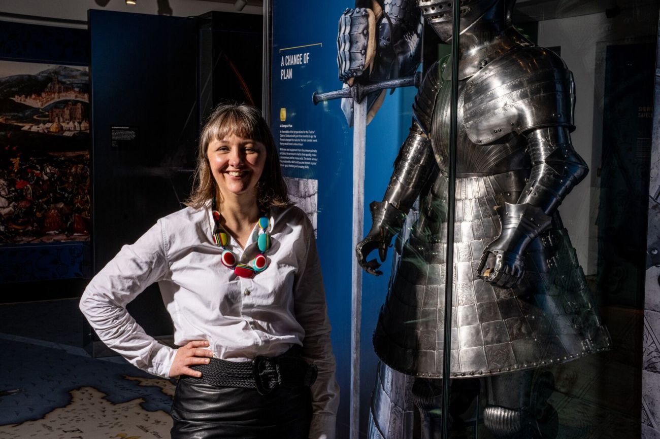 Florence Symington standing next to a full suit of armour in the museum