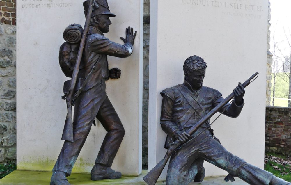 A statue of the closure of the gates at Hougoumont, depicting two soldiers in black metal forcing the gates shut.