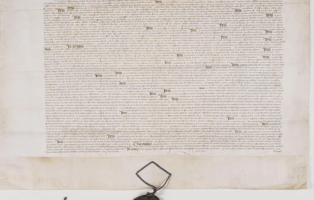 A 15th century document outlining the Treaty of Troyes with a blackened wax seal at the bottom