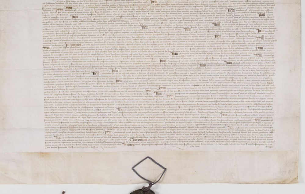 A 15th century document outlining the Treaty of Troyes with a blackened wax seal at the bottom