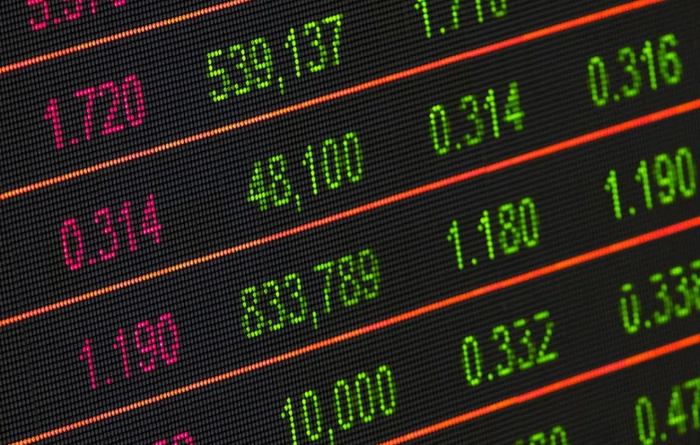 A black screen with red and green numbers separated by orange bars denoting rising and falling stock values.