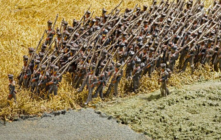 A column of soldiers advance across a field towards the front line