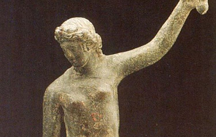 A faded photograph of a topless female warrior holding aloft a sica or curved sword