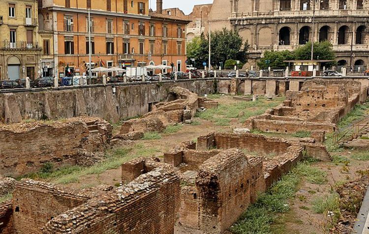 The uncovered ruins of the Ludus Magnus in Rome, next to the Colosseum in the background