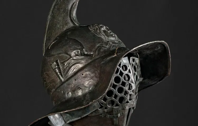 A dark metal helmet with a large griffin crest on top against a dark background