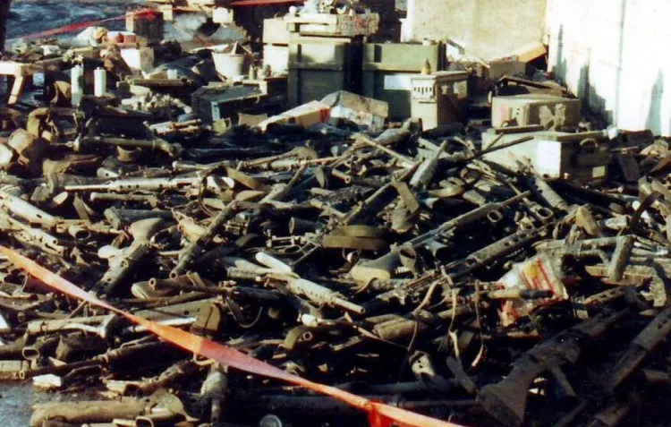 A colour photograph of a large pile of discarded weapons left by Argentine conscripts after the recapture of the Falklands