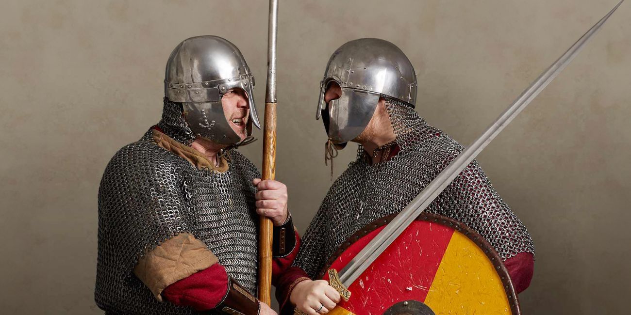 Two Viking and Saxon warriors in mail armour and helmets face off with spear, sword and shield