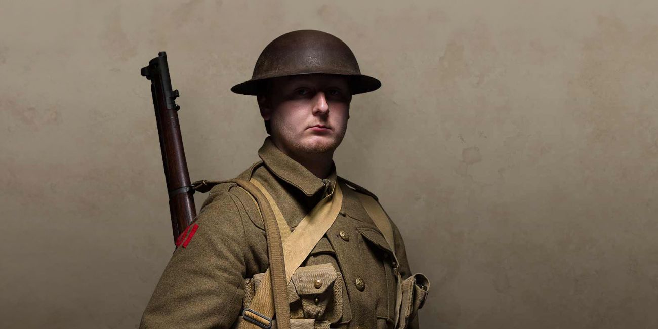 First World War British soldier in battle dress, tin hat and rifle over shoulder