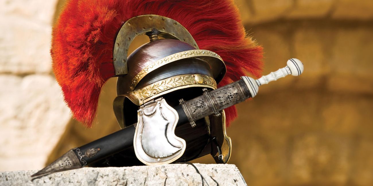 Roman helmet with red plume and a sword