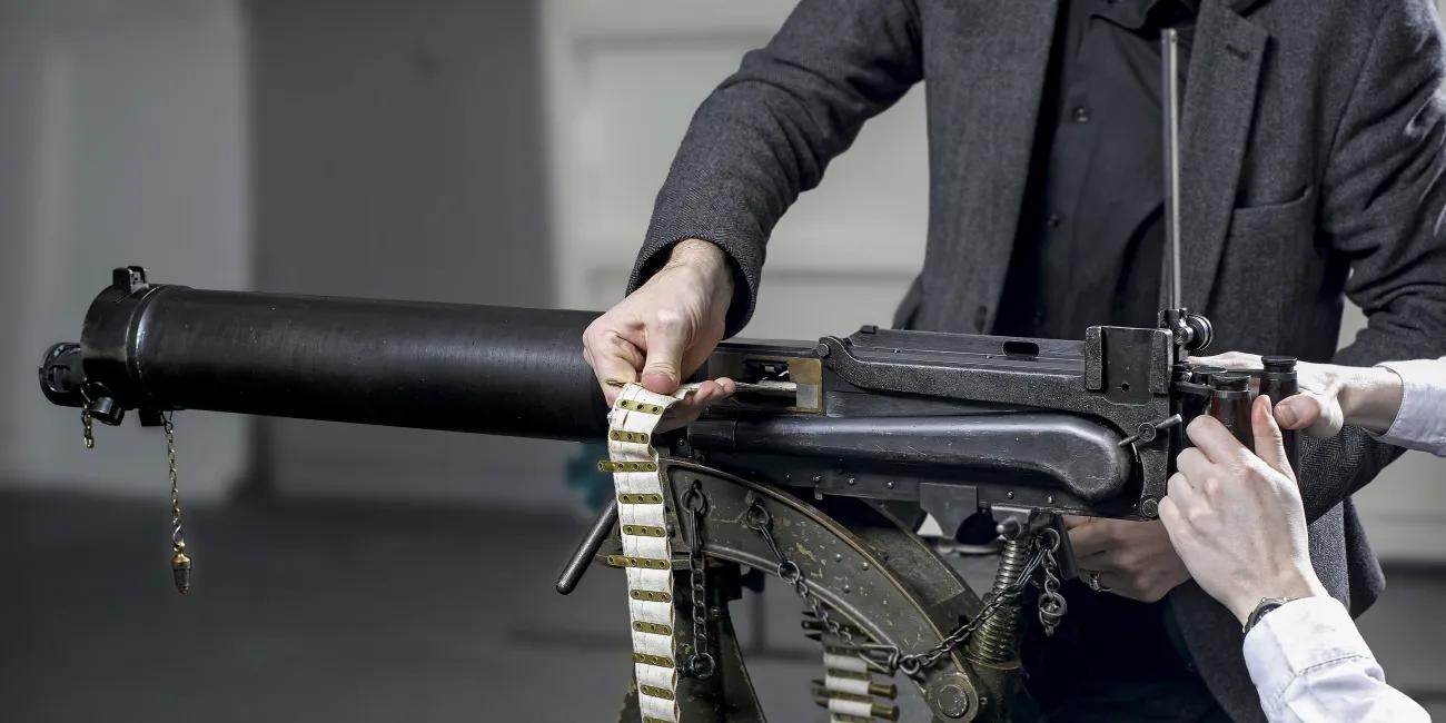 A belt of ammunition being guided into Vickers-Maxim machine gun