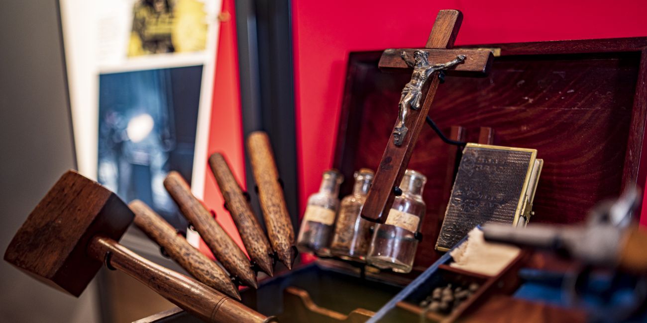 A sinister looking vampire killing kit containing a wooden mallet and four stakes, bottles of garlic, silver and holy water, a crucifix and bible