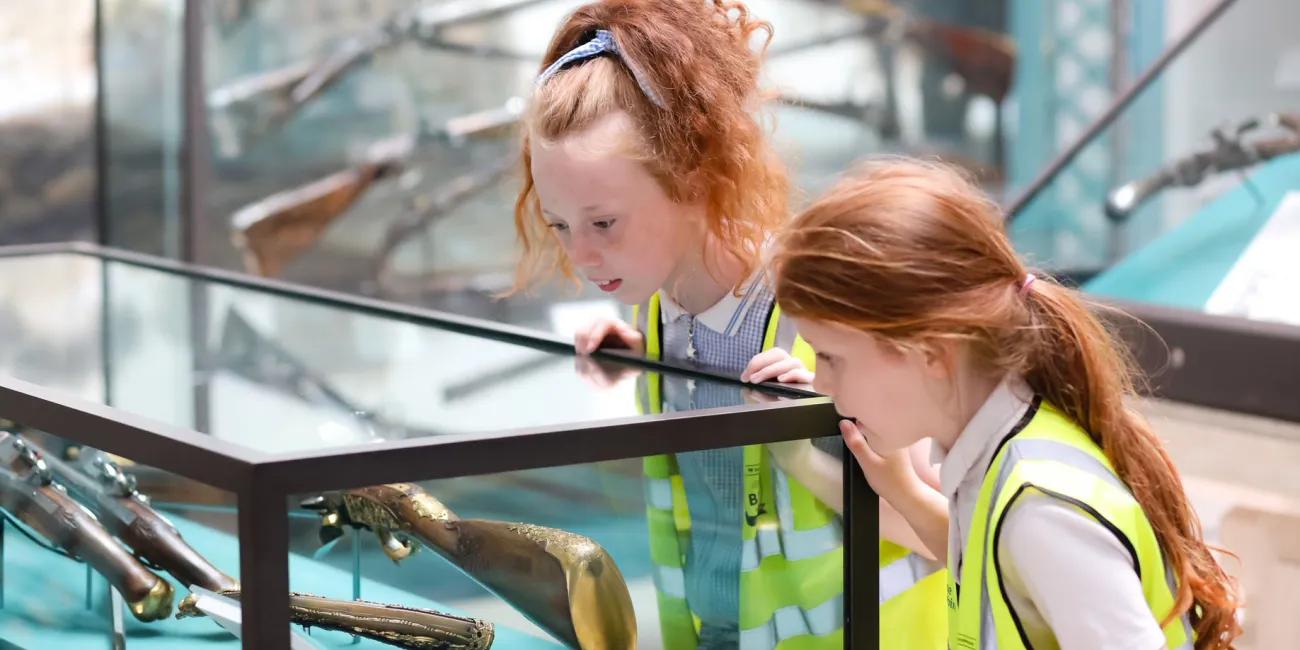 Two children looking at a museum glass display case