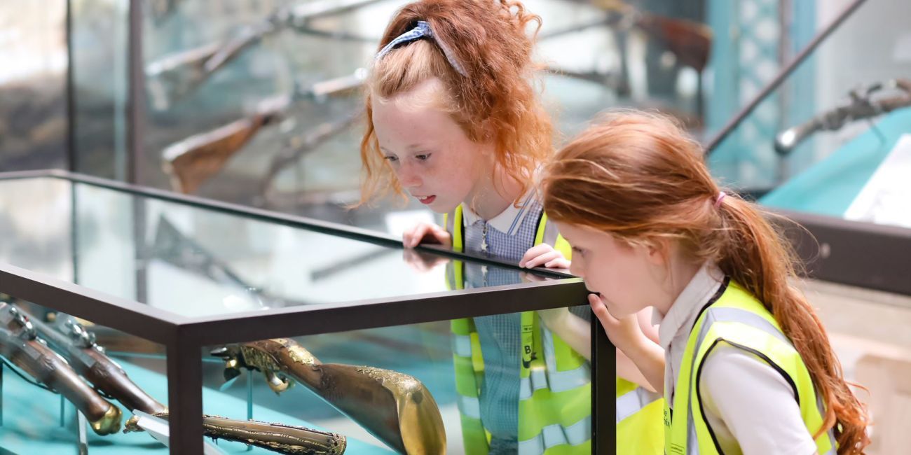 Two children looking at a museum glass display case