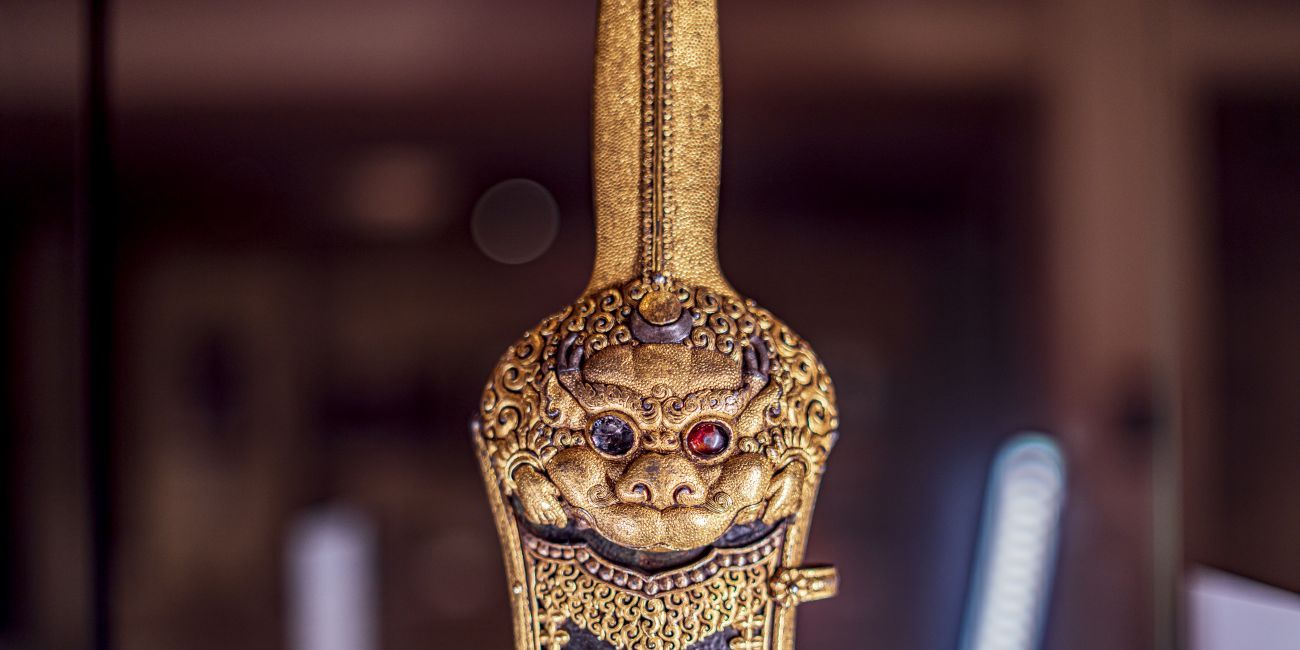 a Chinese sword of the Ming Dynasty decorated with gold and semi precious stones to form the face of a mythical lion