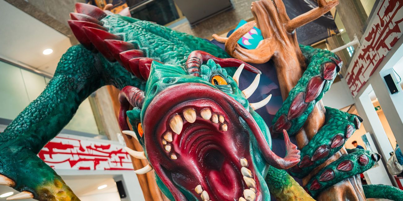 Large green dragon with red spikes and yellow eyes, mouth open to reveal sharp teeth