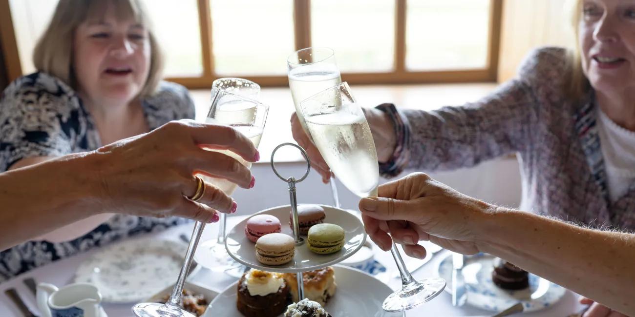 Women clinking glasses over cakes