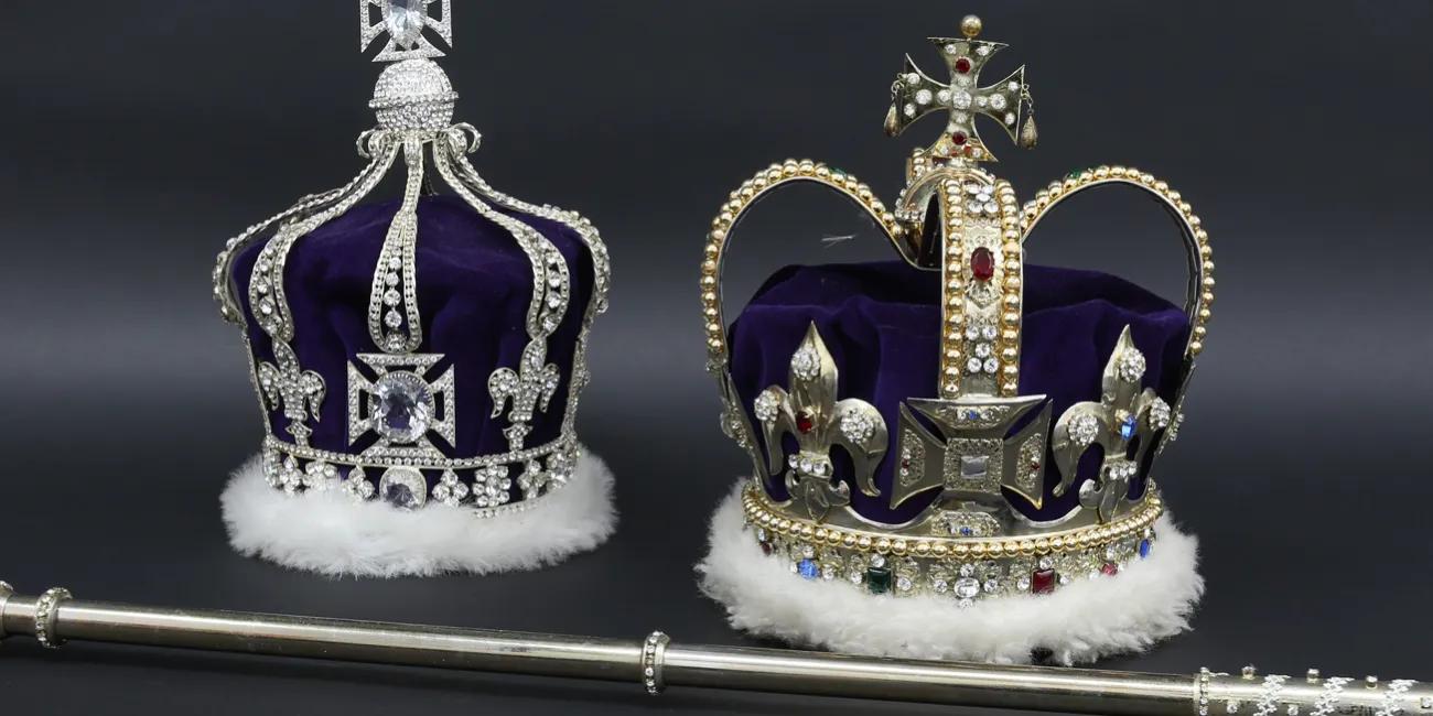 A jewelled crown in white gold with a cross atop, rimmed in purple velvet and white ermine