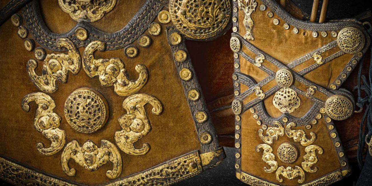 Detailed view of a richly adorned bow case with gilded metalwork and a quiver containing arrows, showcasing elaborate craftsmanship and decorative motifs.