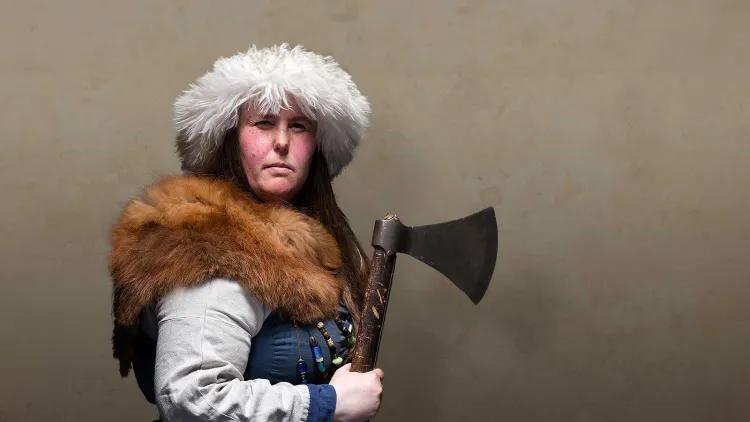 A Viking warrior woman brandishes an axe menacingly