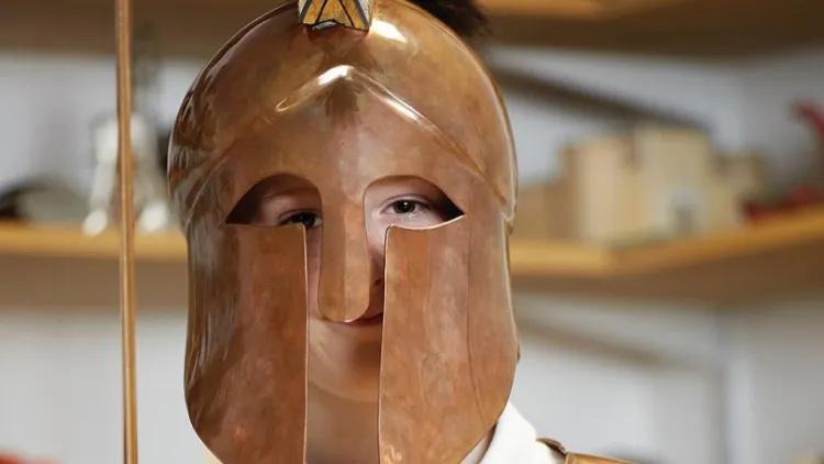 Schoolboy wearing bronze helmet and breastplate