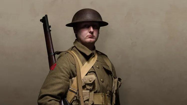 First World War British soldier in battle dress, tin hat and rifle over shoulder
