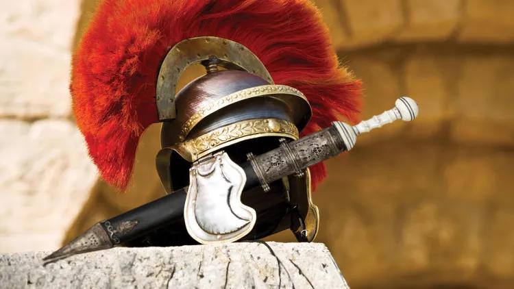 Roman helmet with red plume and a sword