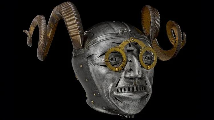Steel helmet in form of a grotesque face with horns and wearing spectacles