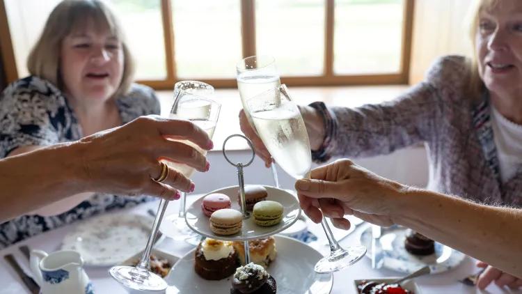 Women clinking glasses over cakes