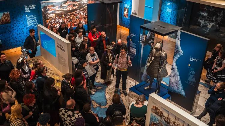 Tour guide speaks to a group of people in the Royal Armouries Tournament Gallery as part of the Queerying the Museum Event