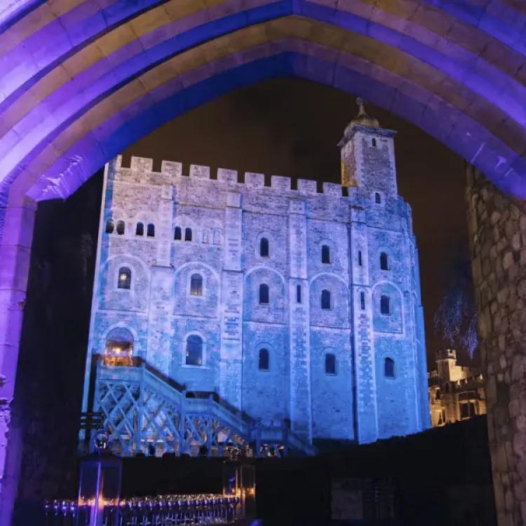 the Tower of London at night seen through an archway