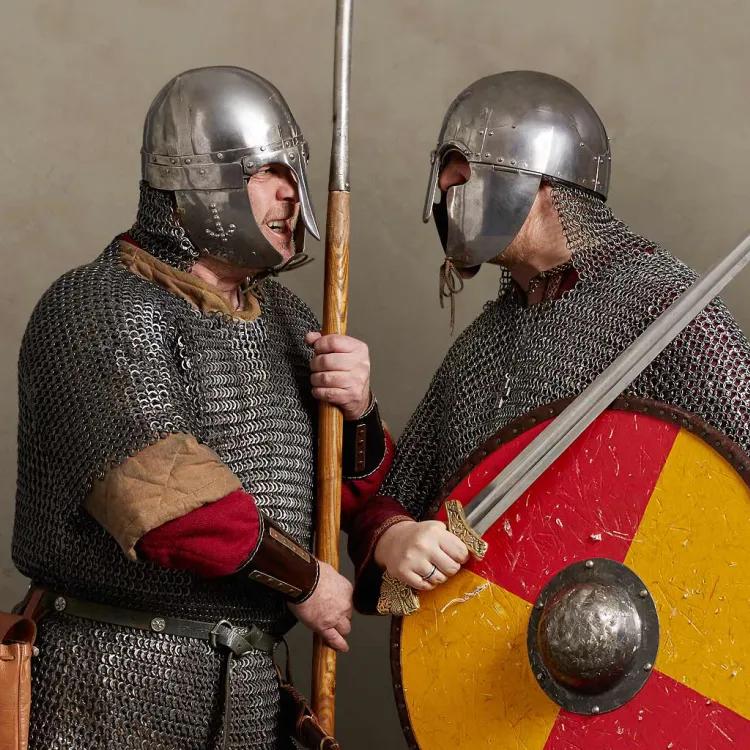 Two Viking and Saxon warriors in mail armour and helmets face off with spear, sword and shield