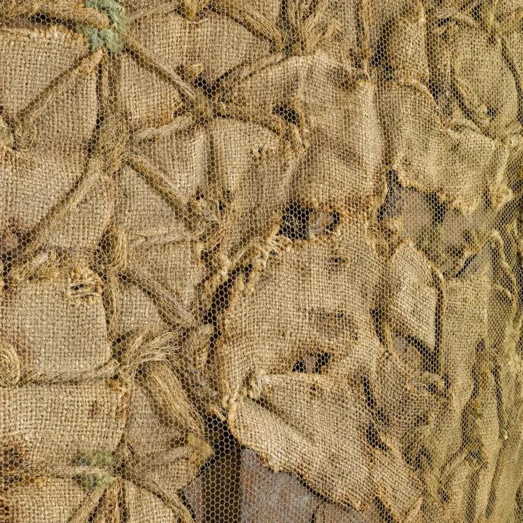 Textile with triangle pattern covered in mesh and rips 