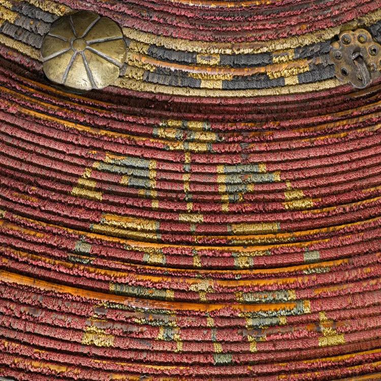 Up close intricate detail of a Kalkan shield, red with gold decor