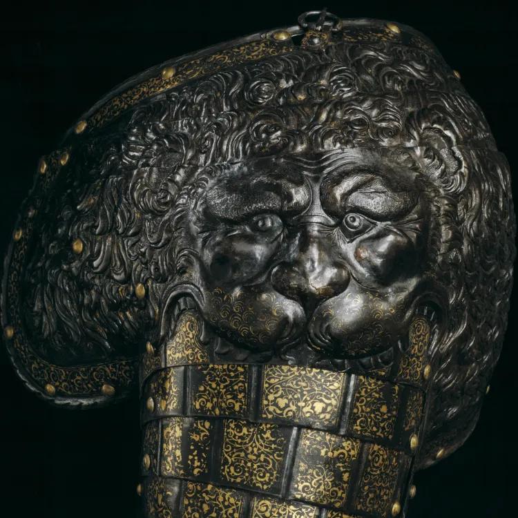 armour decorated with the embossed face of a lion decorated with gold details