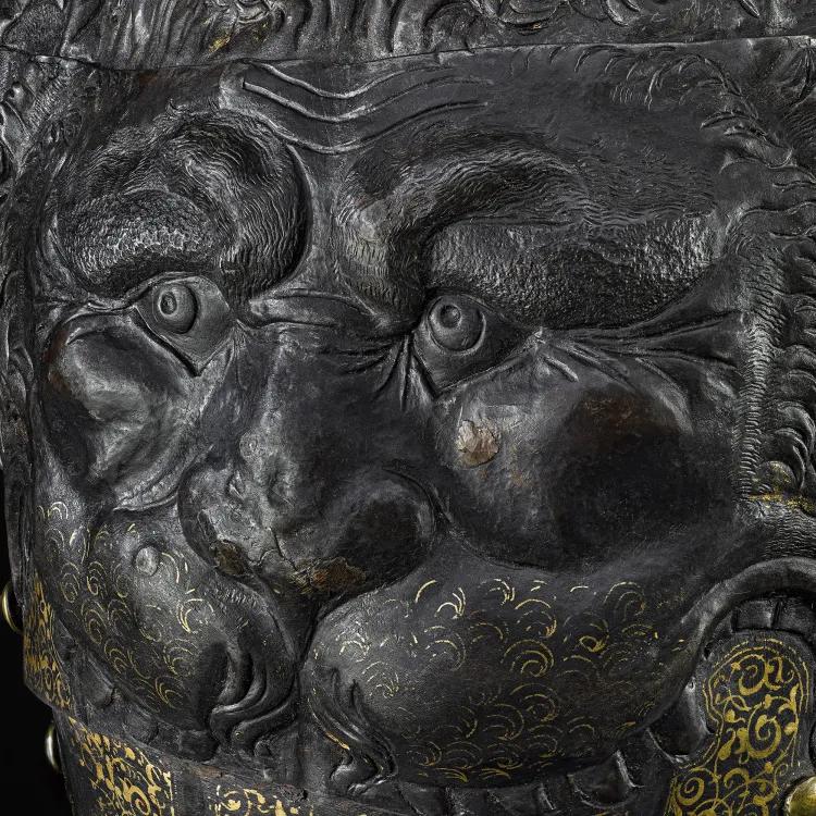 Up close intricate detail of a piece of armour shaped like a lions head