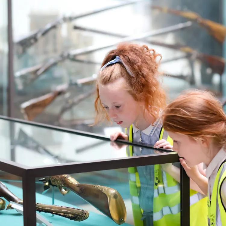 Two children looking at a museum glass display case