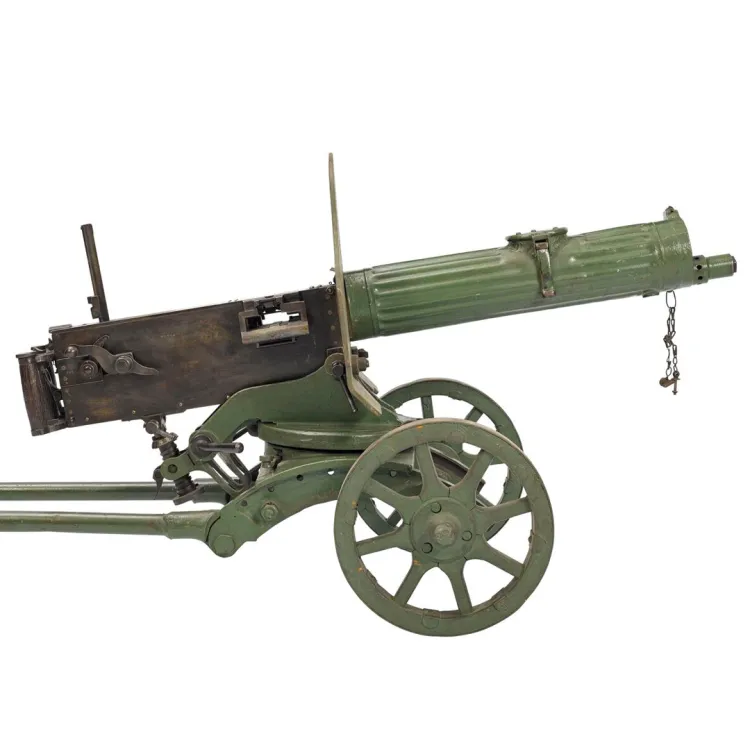 Green machine gun mounted on a wheeled carriage/mount with a shield between the barrel and firing mechanism