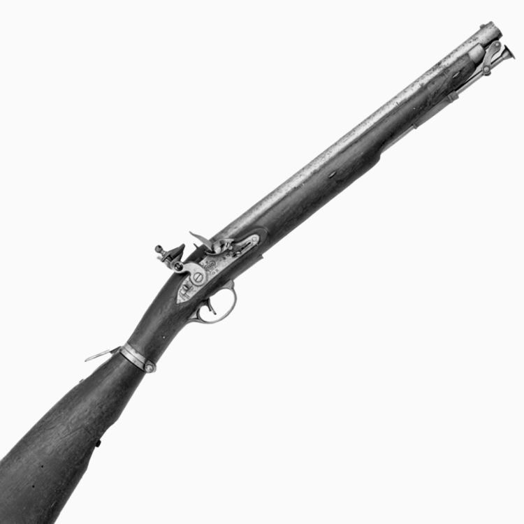 A black and white photo of a short barrelled carbine in wood, steel, and brass trim