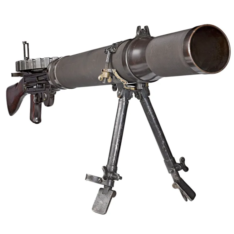 A long barrelled machine gun with metal supports, a wooden grip and a circular, top mounted magazine