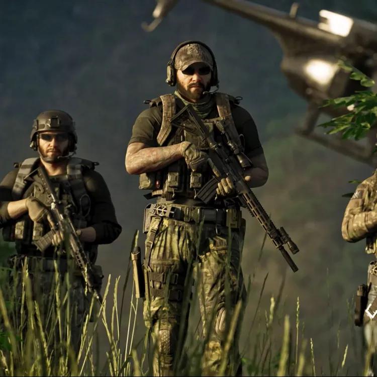 Three soldiers holding firearms with helicopter in the background.