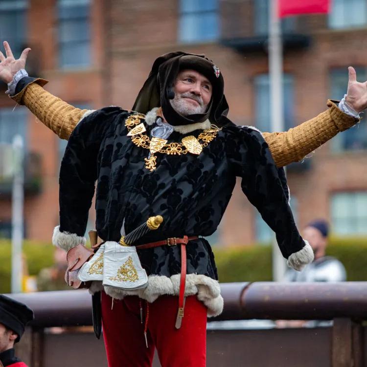 Andy Deane at jousting event posing in front of the crowd with arms out