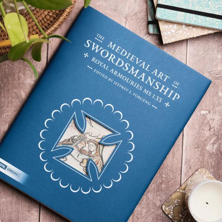 The Medieval art of swordsmanship book on wooden table