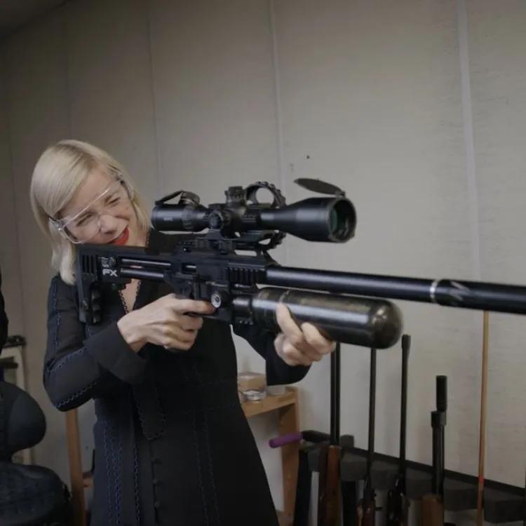Lucy Worsley aiming a firearm stood next to Jonathan Ferguson