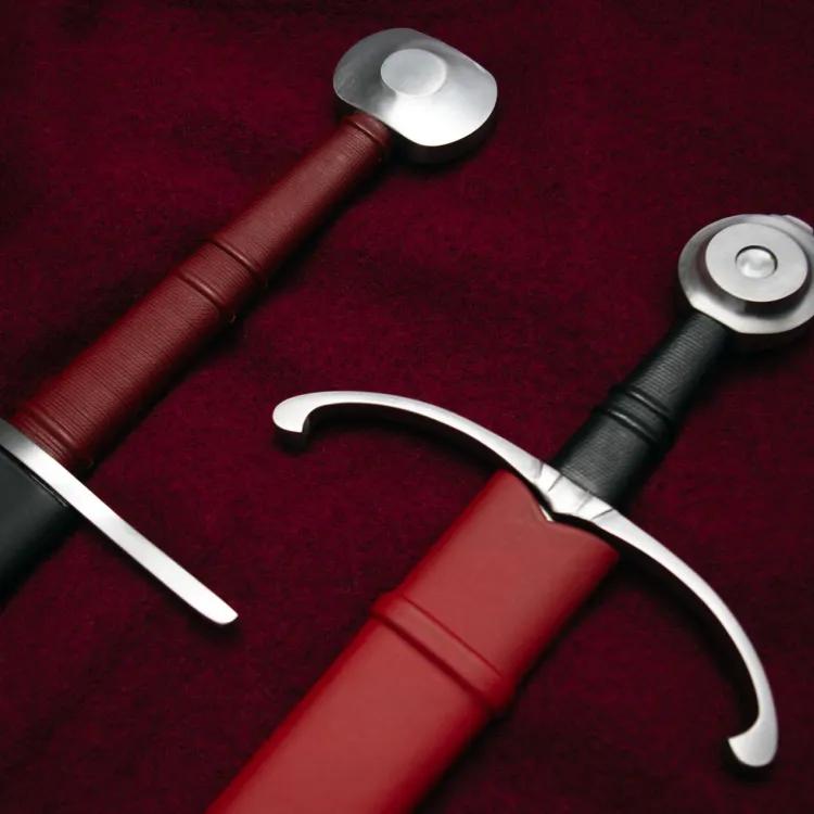 Two sword hilts side by side on red fabric
