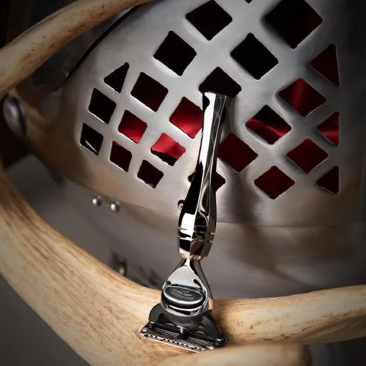 Royal armouries shaver collaboration with wilde and harte showing razor in foreground and helmet in the background.