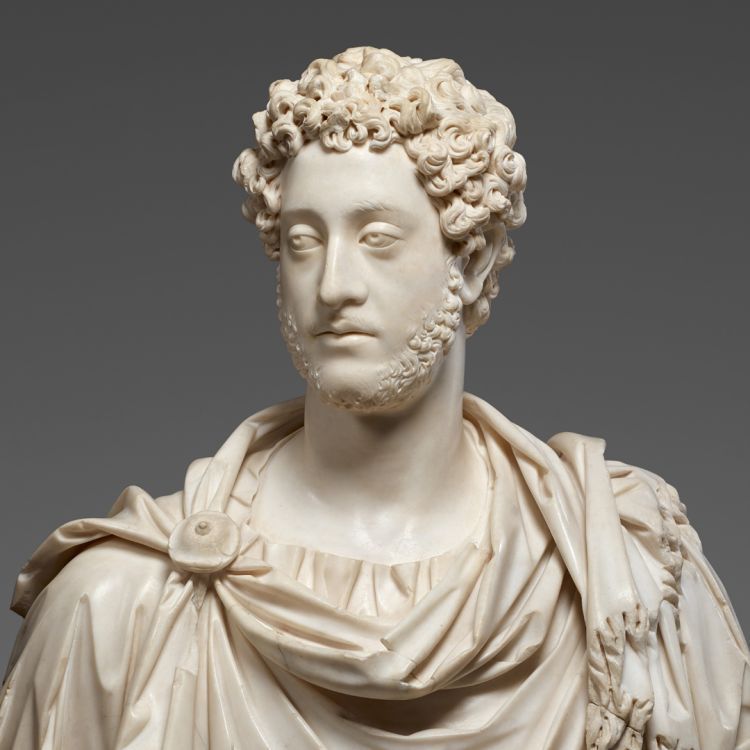 A marble bust of a bearded figure in robes against a dark grey background