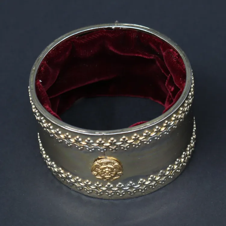 A golden arm band with red velvet lining