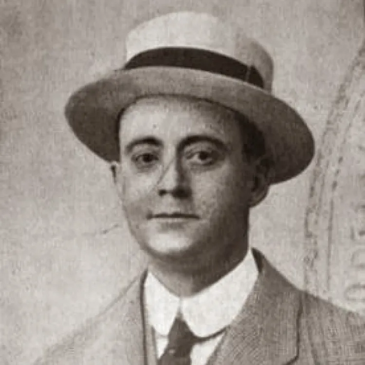 A black and white photograph of a man in suit and tie, with a straw boater hat.