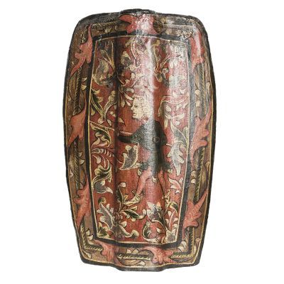 A red rectangular wooden shield painted with the image of a man with a spear