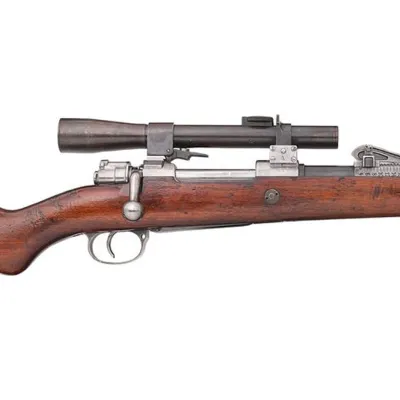 A long, thin optical sight tube attached atop a rifle made in wood and metal